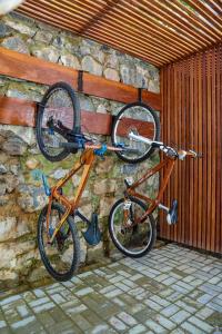 two bikes are hanging on a stone wall at Itacaré Aluguel in Itacaré