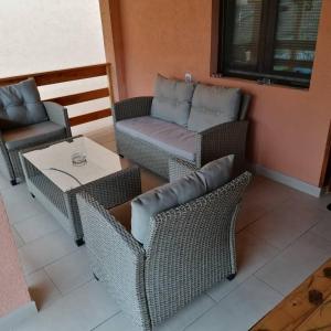 a patio with wicker chairs and a table and a couch at Sobe i apartmani Simic in Ribarska Banja