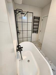 a white bath tub in a bathroom with a window at Modern Cozy Suite - Vracar in Vračar (historical) +8 photos