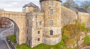 um antigo edifício de pedra com uma torre numa colina em BED Pepin em Namur