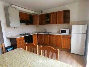 Una cocina con refrigerador blanco y gabinetes de madera. en Casa vacanza Lara, en Santa Brigida