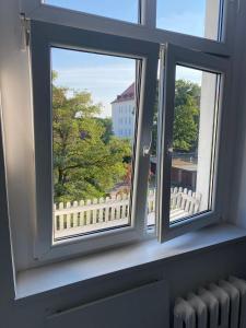 a window with a view of a white fence at Benny 3 in Toruń