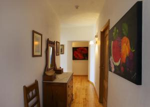 a hallway with a dresser and paintings on the wall at Hospedaria Moiras Encantadas in Paderne
