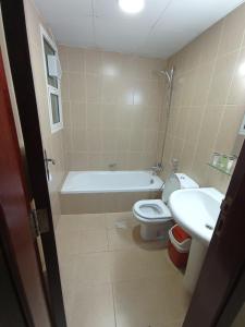 ein Badezimmer mit einer Badewanne, einem WC und einem Waschbecken in der Unterkunft Marbella Holiday Homes - Al Nahda 2BHK in Dubai