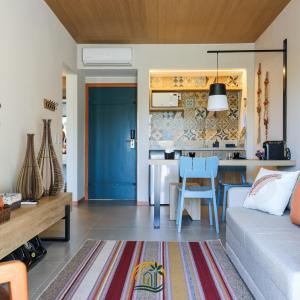 uma sala de estar com um sofá e uma cozinha em Flat da Mata - Resort Quinta Santa Bárbara em Pirenópolis