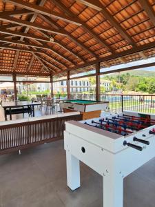 a patio with two ping pong tables and pool tables at Flat da Mata - Resort Quinta Santa Bárbara in Pirenópolis