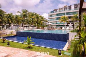 帕奈米林的住宿－Qavi - Flat Resort Beira Mar Cotovelo #InMare322，一座楼前棕榈树游泳池