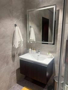 uma casa de banho com um lavatório e um espelho em Mirage Residence Apartment Accra em Acra