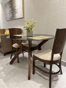 uma mesa de jantar e cadeiras com uma planta em Mirage Residence Apartment Accra em Acra
