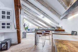 an industrial style kitchen with a bar with stools at apartamento reformado en la plaza mayor in Madrid