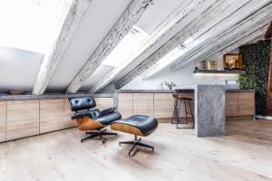 a loft kitchen with leather chairs and a bar at apartamento reformado en la plaza mayor in Madrid
