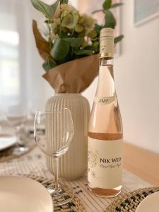 een fles wijn en een glas op een tafel bij Boho Home - mit Balkon, Parkplatz und Netflix in Trier