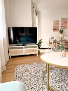 een woonkamer met een grote flatscreen-tv bij Boho Home - mit Balkon, Parkplatz und Netflix in Trier