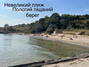 a beach with people laying on the sand and water at Flower Breeze in Chebanka