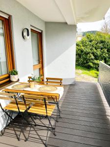 een terras met een tafel en stoelen bij Boho Home - mit Balkon, Parkplatz und Netflix in Trier