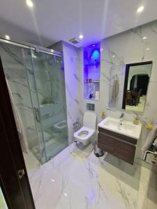 a bathroom with a toilet and a shower and a sink at Superbe appartement lumineux in Marrakesh