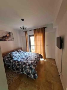 a bedroom with a bed and a window at Superbe appartement lumineux in Marrakesh