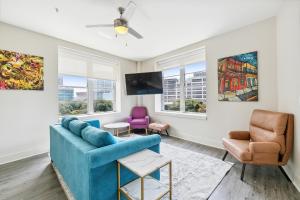a living room with a blue couch and two chairs at Modern Condo Walking Distance to Must-See Attractions of NOLA in New Orleans