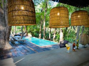 a table with wine glasses and chandeliers and a swimming pool at Sakae Paradise Resort in Lusaka