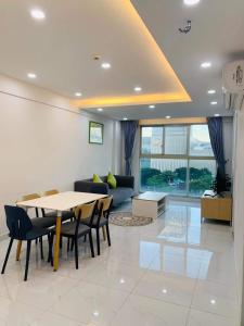 a living room with a table and chairs and a couch at SECC Scenic Valley Apartment in Ho Chi Minh City