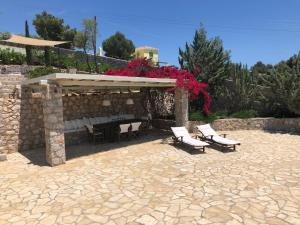 - un pavillon avec des chaises, une table et des fleurs dans l'établissement Cozy vacation home, à Porto Heli