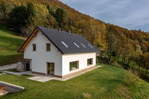 una casa bianca con un tetto nero su una collina di Styria Estate, near Terme Olimia Spa Resort a Podplat