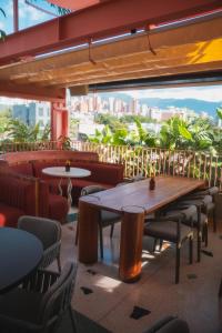 einen Tisch und Stühle in einem Restaurant mit Aussicht in der Unterkunft The Somos Bold Hotel in Medellín