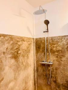 eine Dusche im Bad mit schmutziger Wand in der Unterkunft L'Ylang Ylang Auberge d'AMBATOLOAKA in Ambatoloaka