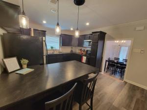 a kitchen with a large black counter and a dining room at Cottage in Downtown Houma in Houma