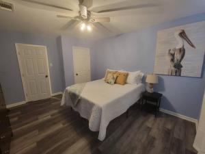 a bedroom with a bed with a bird painting on the wall at Cottage in Downtown Houma in Houma