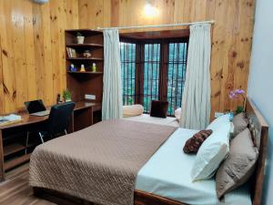a bedroom with a bed and a desk with a computer at The Rustic Manor - Homestay in Bangalore