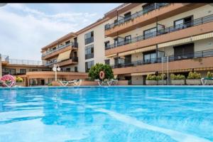 une grande piscine en face d'un bâtiment dans l'établissement Apartamento céntrico Playa de Aro con piscina., à Platja d'Aro