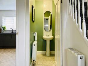 La salle de bains est pourvue d'un lavabo et d'un miroir. dans l'établissement uSnooz I Charming 4-Bed Halifax Home with Garden, à Halifax