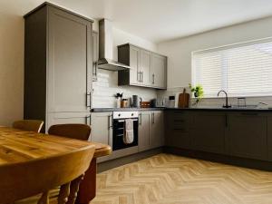 Il comprend une cuisine avec une table et du parquet. dans l'établissement uSnooz I Charming 4-Bed Halifax Home with Garden, à Halifax