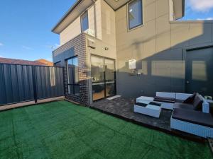 a patio of a house with a green lawn at Rosie Townhouse - Modern home in Sunshine in Albion