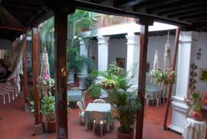 a patio with a table and chairs and plants at Hotel Las Nieves in Girón
