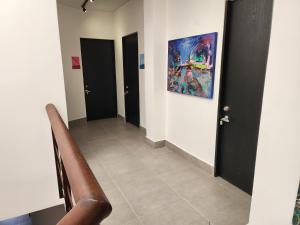 a hallway with two doors and a painting on the wall at Casa Arte Coliving in Pereira