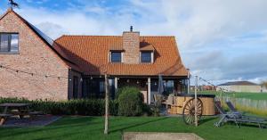 una casa de ladrillo con un banco y una mesa en Florentinus met hottub, afgesloten tuin en overdekt terras, en Veurne