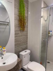 a bathroom with a toilet and a sink and a mirror at SECC Scenic Valley Apartment in Ho Chi Minh City