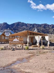 um edifício no deserto com montanhas ao fundo em Paramitas - cabañas y hostel de montaña em Uspallata