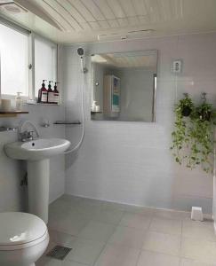 a white bathroom with a toilet and a sink at Stay Mellow in Seoul