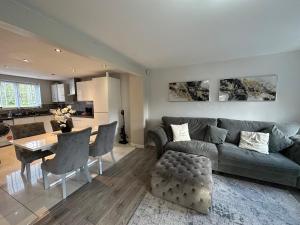 een woonkamer met een bank en een tafel bij Waterside 4BR Townhouse Stretford, FREE Parking in Manchester