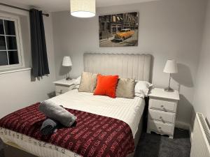 een slaapkamer met een bed met een oranje kussen erop bij Waterside 4BR Townhouse Stretford, FREE Parking in Manchester