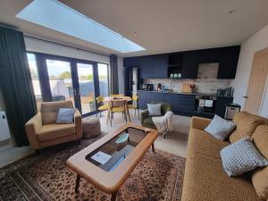 Rudgleigh Lodge by Cliftonvalley Apartments في بريستول: غرفة معيشة مع كنب وطاولة ومطبخ