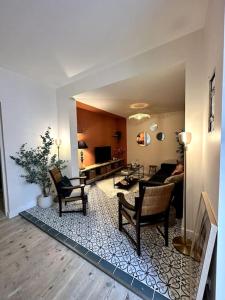 sala de estar con sofá y sillas en Magnifique appartement Eaux Bonnes T5 en Eaux-Bonnes