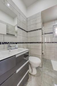 a white bathroom with a toilet and a sink at Joli Appartement de vacances in Écouen