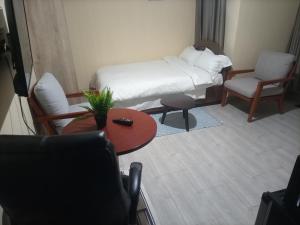 a small room with a bed and a table and chairs at Nyatana suite (Fully furnished apartments) in Narok