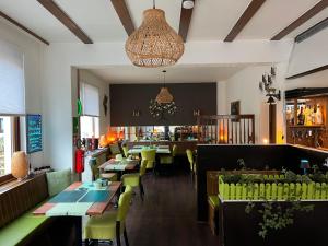 a restaurant with tables and chairs and a bar at Am Obersee Hotel in Simmerath