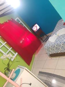 Habitación con cama y maleta roja en Mel Pousada, en Macaé