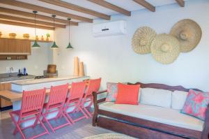 ein Wohnzimmer mit einem Sofa und einigen Stühlen in der Unterkunft Excelente aparamento em Milagres à 100 metros da Praia in São Miguel dos Milagres